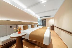 - une grande chambre avec un grand lit et une table dans l'établissement 三间堂百年徽商俞家 婺源月亮湾店, à Wuyuan