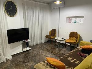 a living room with a couch and a flat screen tv at River Side Apartment in Prizren