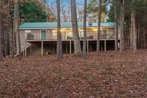 a large house with a deck in the woods at New to listing Dorsey Dock Retreat w Dock in Hartwell