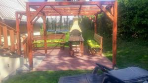 a wooden gazebo with a bench in a yard at Chata Wellness Březka in Libuň
