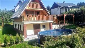 a house with a large tub in front of it at Chata Wellness Březka in Libuň