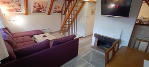 a living room with a couch and a fireplace at Chata Wellness Březka in Libuň