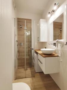 ein weißes Badezimmer mit Waschbecken und Dusche in der Unterkunft Szyndzielnia Park no 23 # z kortem tenisowym, rowerownią # LUX # nestapartmenty in Bielsko-Biała