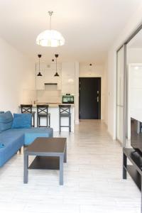 ein Wohnzimmer mit einem blauen Sofa und einem Tisch in der Unterkunft Szyndzielnia Park no 23 # z kortem tenisowym, rowerownią # LUX # nestapartmenty in Bielsko-Biała