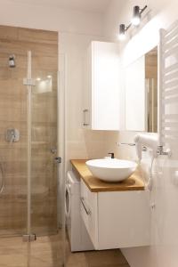 ein weißes Badezimmer mit Waschbecken und Dusche in der Unterkunft Szyndzielnia Park no 23 # z kortem tenisowym, rowerownią # LUX # nestapartmenty in Bielsko-Biała + 20 Fotos