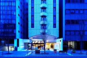 a building with a tree in front of it at EN HOTEL Hakata in Fukuoka