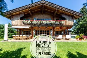a log house with a sign in front of it at Harmony Deluxe Chalet, Sauna & Fireplace by Belle-Stay in Reith bei Kitzbühel