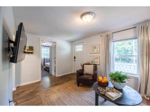 a living room with a couch and a table and a television at Downtown Bungalow Less than 1.5 Miles to UGA in Athens