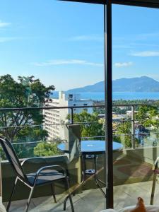 - Balcón con vistas, mesa y sillas en Hill Bay Suites Hotel, en Patong Beach