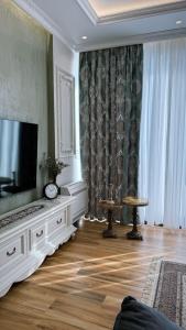 a living room with a flat screen tv on a dresser at Bela's Apartment in Kamëz