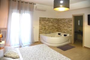 a bathroom with a tub and a bed in a room at B&B La Perla & Suites in Bari