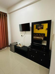 Una sala de estar con un televisor de pantalla plana en la pared. en Funwhales Rest House, en Negombo