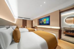 Cette chambre comprend 2 lits et une télévision. dans l'établissement 三间堂百年徽商俞家 婺源月亮湾店, à Wuyuan
