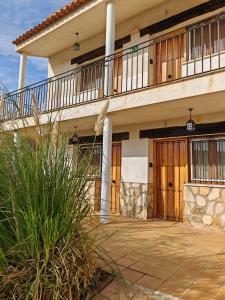 ein großes Haus mit einer Veranda und einem Balkon in der Unterkunft El Moral Centro de Turismo Rural in Valdecañas