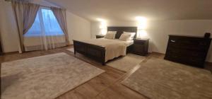 a bedroom with a bed and a dresser and a window at Kytila Apartments in Chitila