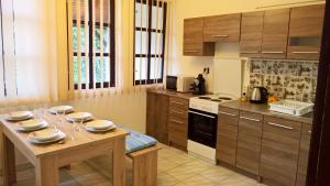ミシュコルツにあるLa Boheme Apartmanのキッチン(木製テーブル、ワイングラス付)