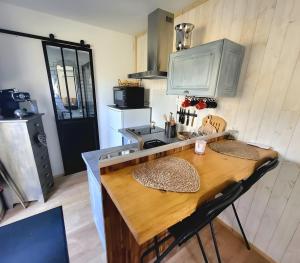 a kitchen with a wooden table and a counter top at La Tiny Des Bruyères 