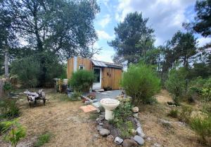 a tiny house in a yard with a garden at La Tiny Des Bruyères  +9 photos