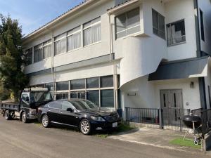 a black car and a truck parked in front of a building at Kami no Tsuki - Vacation STAY 15816 in Akiruno +7 photos