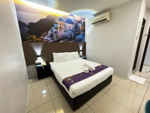 a bedroom with a bed with a painting on the wall at Best View Hotel Puchong in Puchong