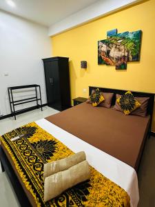 Dos camas en una habitación con paredes amarillas. en Funwhales Rest House, en Negombo 51 fotos más