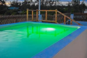 an empty swimming pool with a green floor and a wooden fence at Mangrove Sunset Villa in Watamu +13 photos
