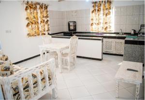 a kitchen with a table and chairs in it at Mangrove Sunset Villa in Watamu
