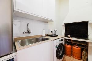 a kitchen with a sink and a washing machine at Casa Las 4 Estaciones in Caudiel