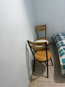 twee houten stoelen naast een bed bij Blue Zone in Kigali