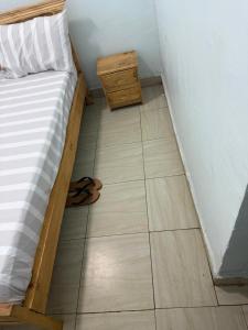 een slaapkamer met een bed en een sandaal op de vloer bij Blue Zone in Kigali