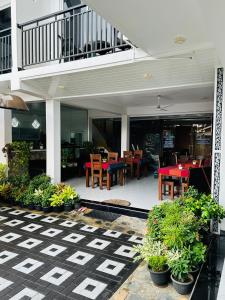 Un restaurante con un patio con mesas y sillas. en Funwhales Rest House, en Negombo