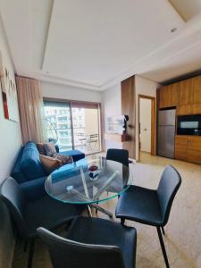 a living room with a glass table and chairs at BenHost Appartement Casablanca Maarif in Casablanca