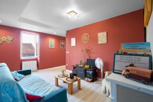 a living room with red walls and a blue couch at Maison Tiny Bwa in Saint-Cernin-de-lʼHerm