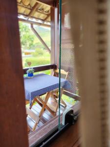 a table and a chair on a balcony at Chalés Metanóia in São Pedro da Serra