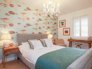 a bedroom with a bed and a chandelier at Seaspell Beach House in Padstow
