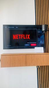 a tv sitting on top of a wooden shelf at BenHost Appartement Casablanca Maarif in Casablanca