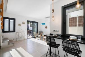 a kitchen with black counter chairs and a table at Villa - Canas Da Ria - Piscine in Santa Luzia