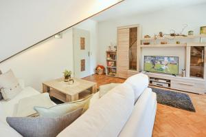 a living room with a white couch and a tv at Ferienwohnung KonradAlbrecht in Torgelow am See