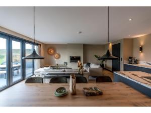 Una cocina y una sala de estar con una mesa y un sofá. en Modern villa in De Cocksdorp near the beach, en De Cocksdorp