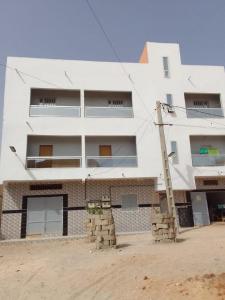 a large white building with a lot of windows at Chez ABDOUL in Rufisque