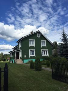 zielony dom z białymi oknami na dziedzińcu w obiekcie Villa Kniazia w Białowieży
