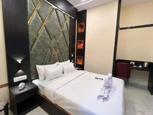 a hotel room with a bed with shoes on it at Sky Suites By Glitz Hotels Nr Internatinational Airport Mumbai in Mumbai