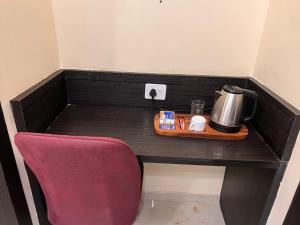 a table with a chair and a coffee maker on it at Sky Suites By Glitz Hotels Nr Internatinational Airport Mumbai in Mumbai +11 photos