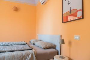 a bedroom with orange walls and a bed and a lamp at Casa Castanea in Trecastagni Catania in Trecastagni