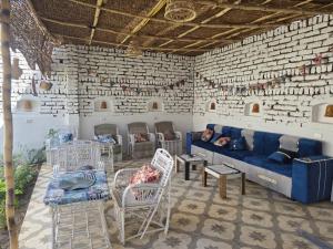ein Wohnzimmer mit einer blauen Couch in einer Ziegelwand in der Unterkunft House of Dreams apartments Luxor in Luxor