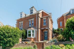 a brick house with a bench in front of it at Capstone in Swanage