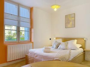a bedroom with a bed and two windows at Teeny Ponta Plage in Royan