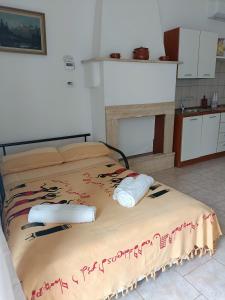a large bed in a room with a kitchen at Casetta Wetto' in Monopoli