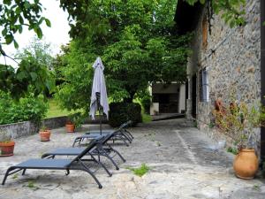 a group of chairs with an umbrella next to a building at CASERÍO MENDOZA by Urdaibai Experience in Gautegiz Arteaga