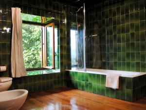 a green tiled bathroom with a tub and a window at CASERÍO MENDOZA by Urdaibai Experience in Gautegiz Arteaga +31 photos